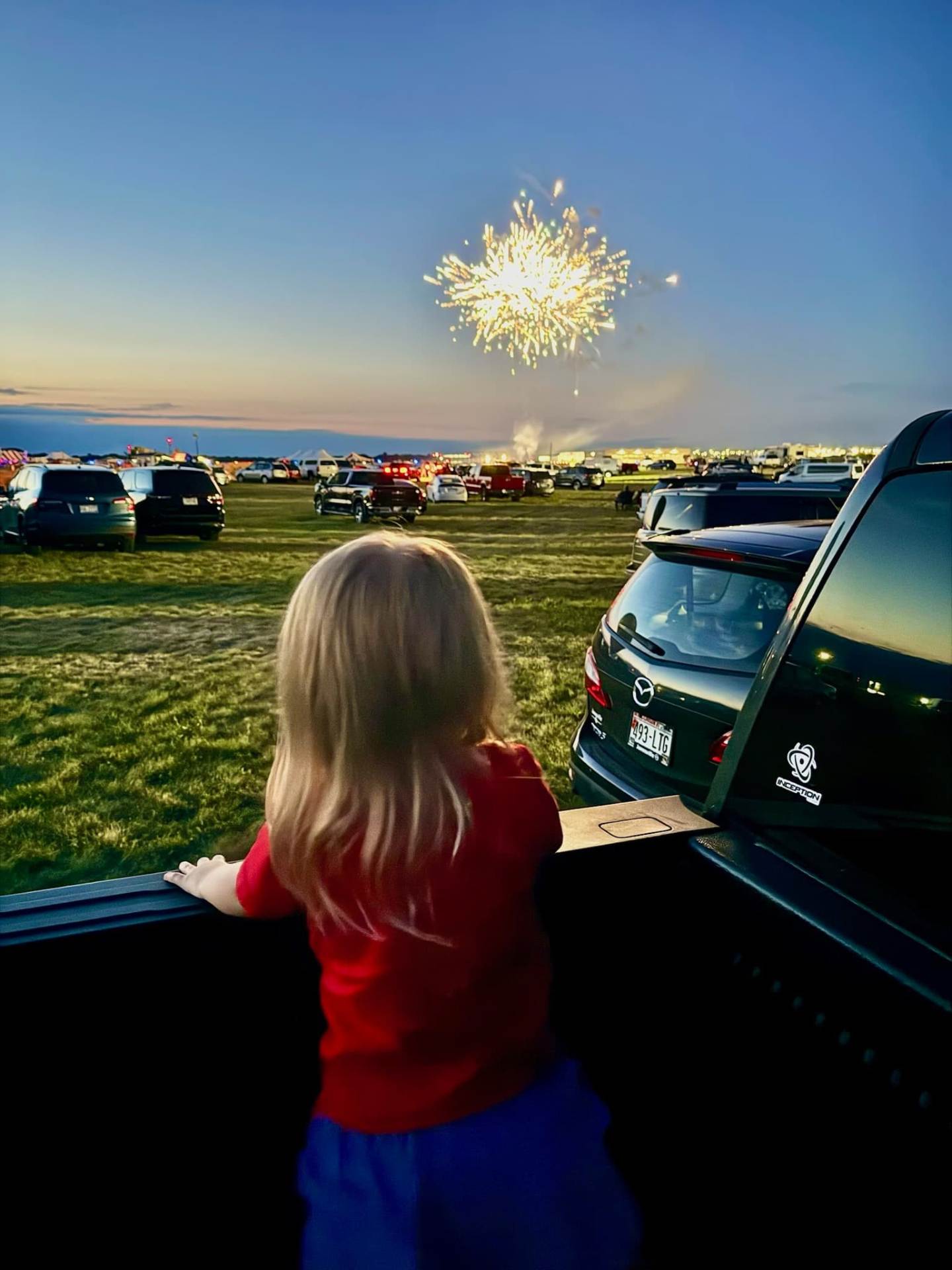 Small child watching the fireworks from within a truck