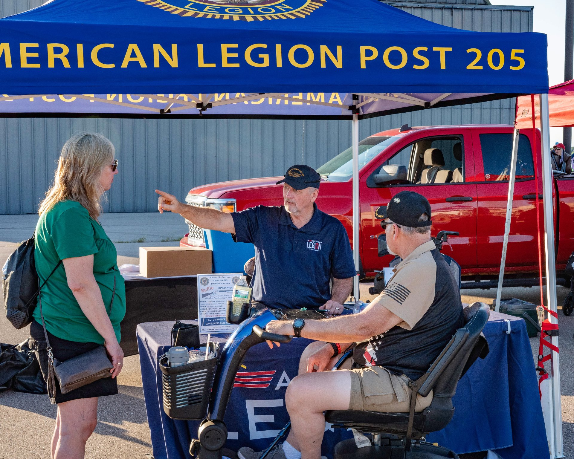 A person at the American Legion Post booth pointing directions
