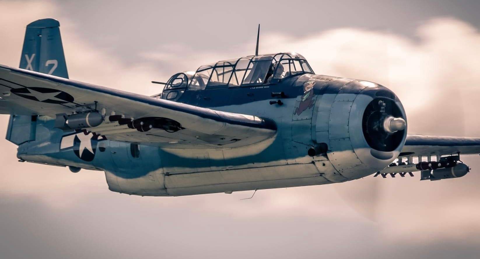 Close-up of vintage military aircraft cockpit and fuselage in flight