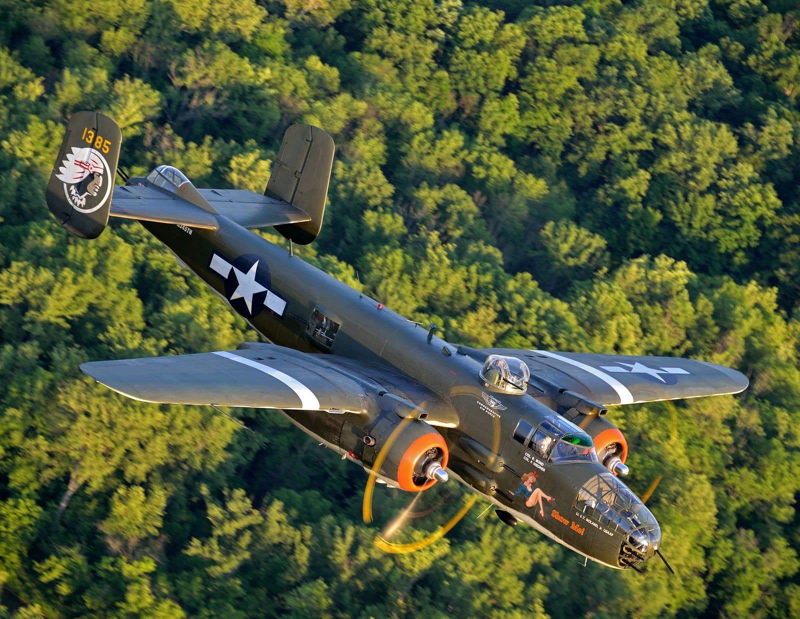 B-25 flying over forested landscape