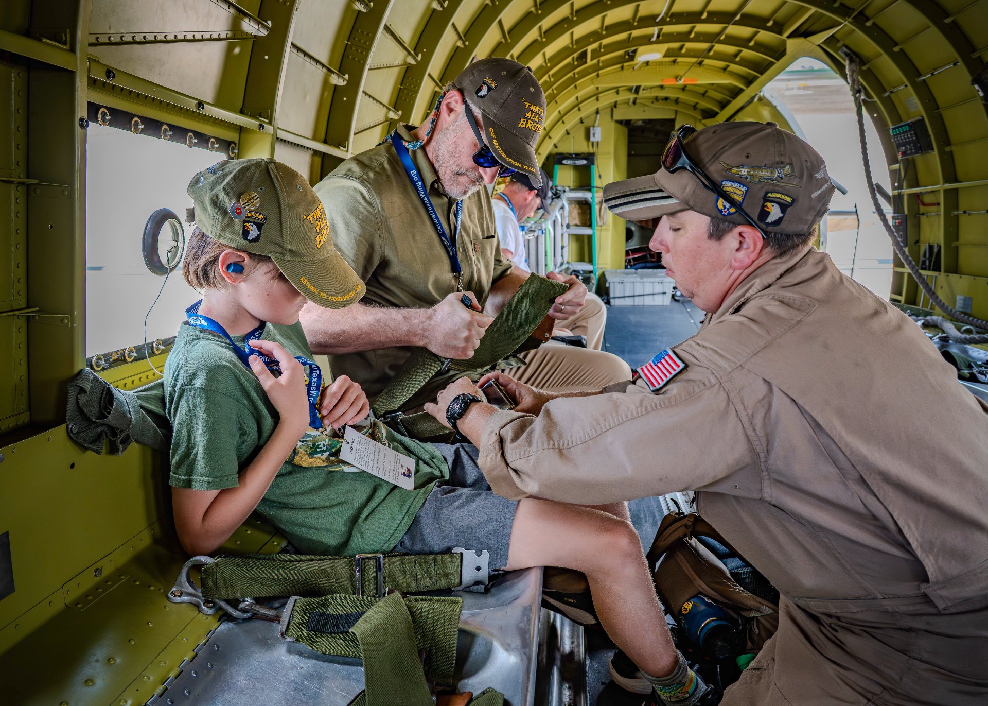 Passengers seated inside That's All, Brother as a crew member helps secure a harness