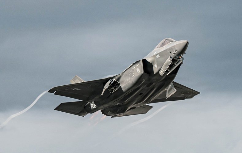 F-35A Lightning II banking against a clear sky.