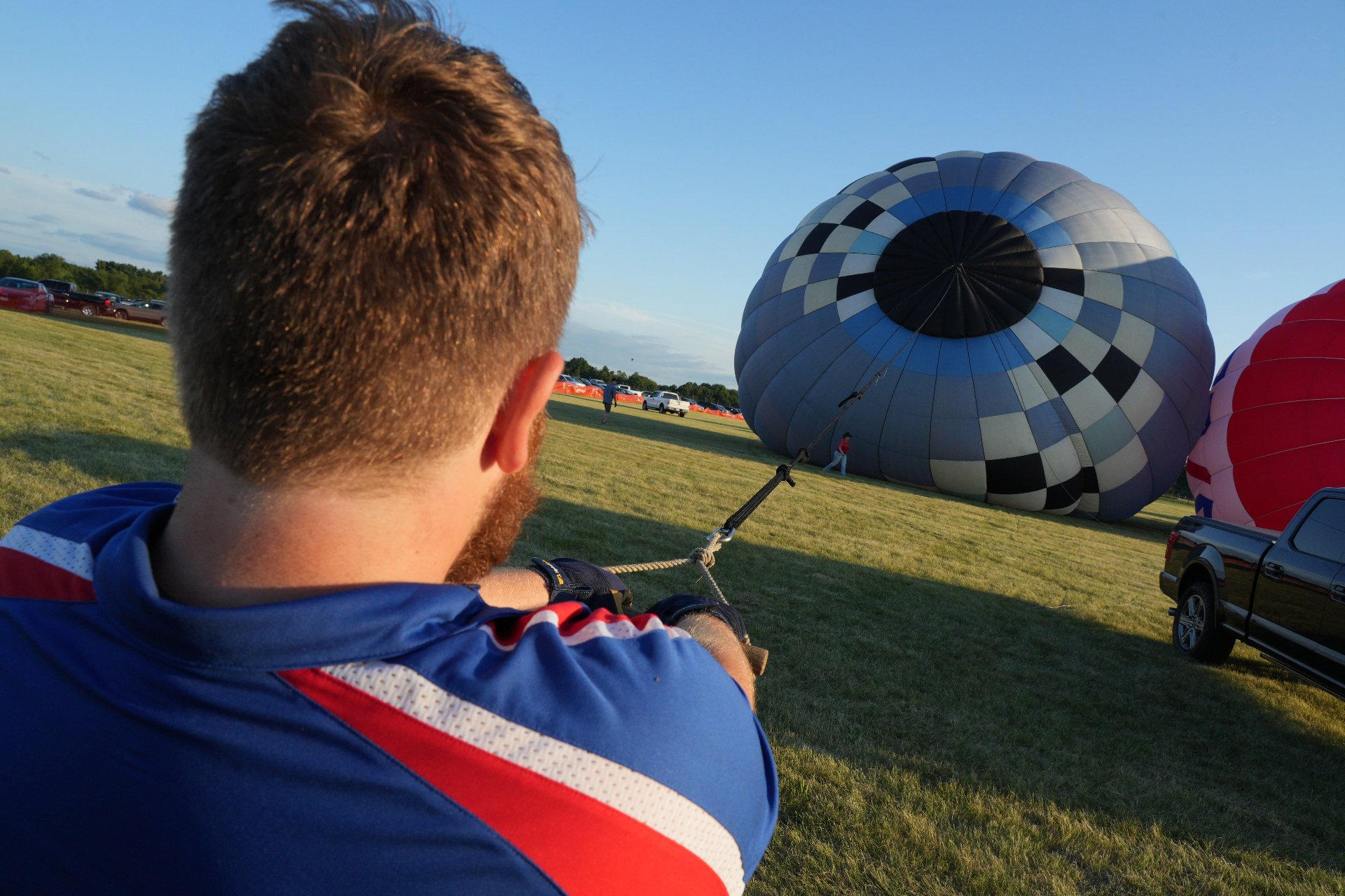 Man pulling a hot air balloon up as it fills