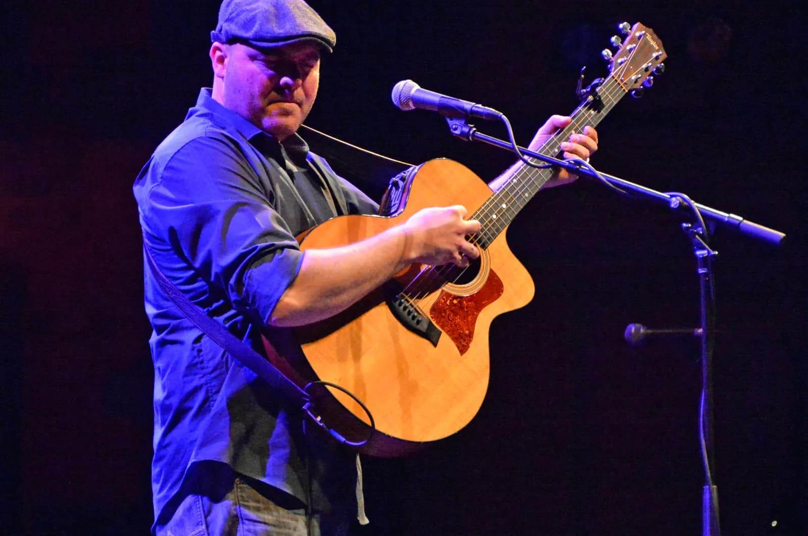 Man on a stage playing a guitar