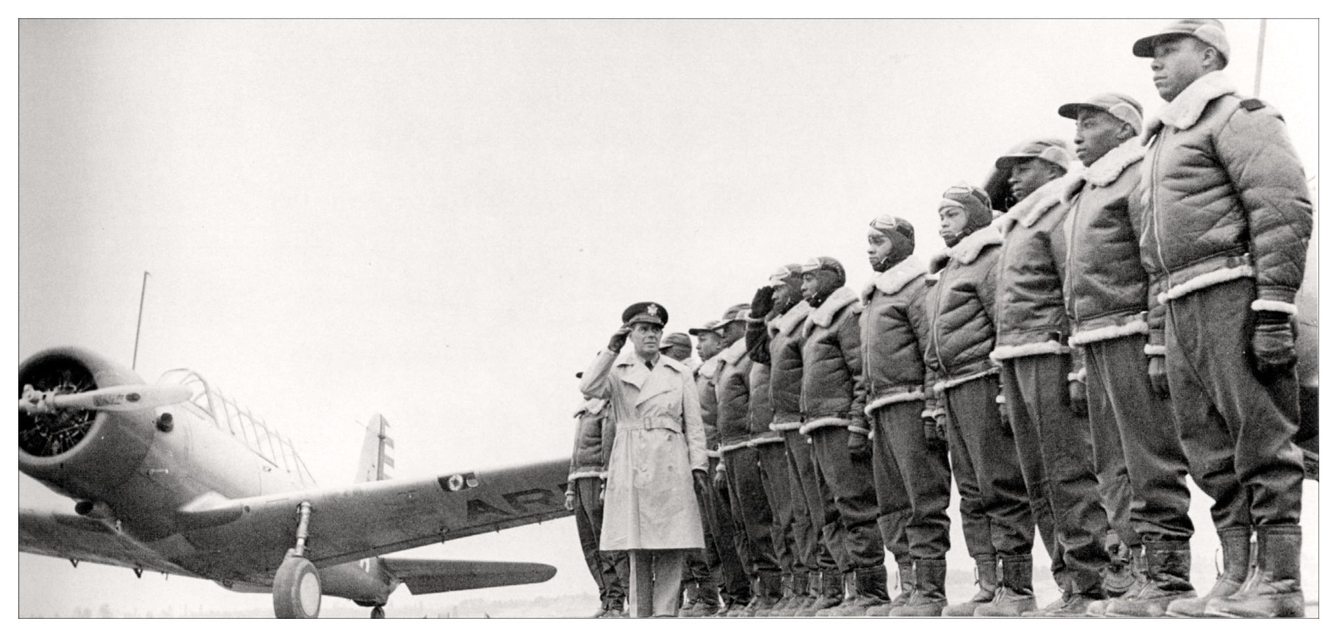 Tuskegee Airmen standing at attention while a military officer salutes