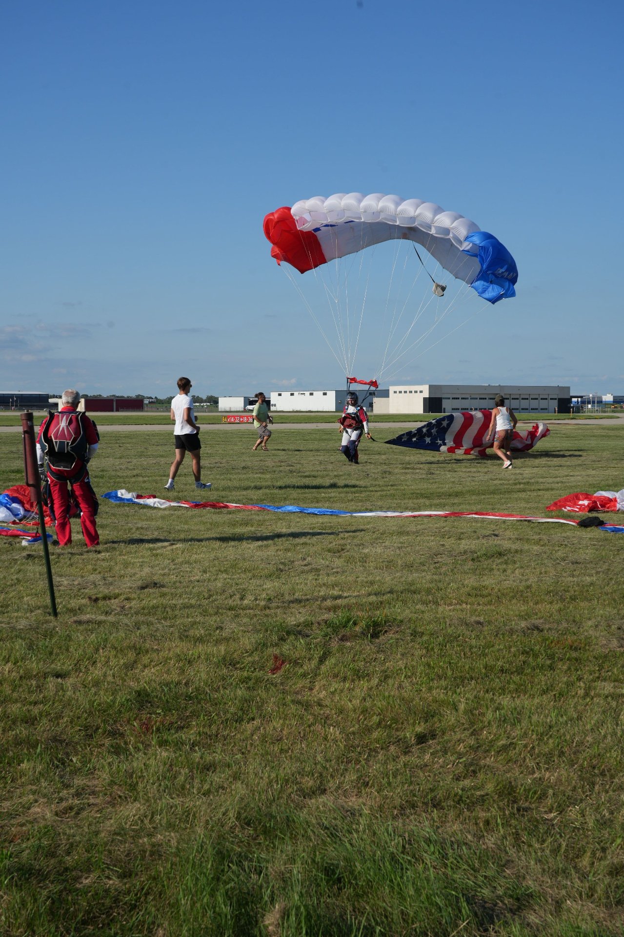 Skydiver just landing with people running to help them