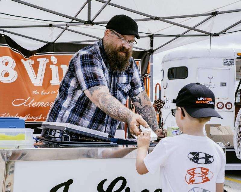 Man handing ice cream to a child